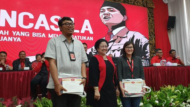 Ketua Umum PDIP Megawati Soekarnoputri memberikan buku kepada media, Senin (19/8/2019).