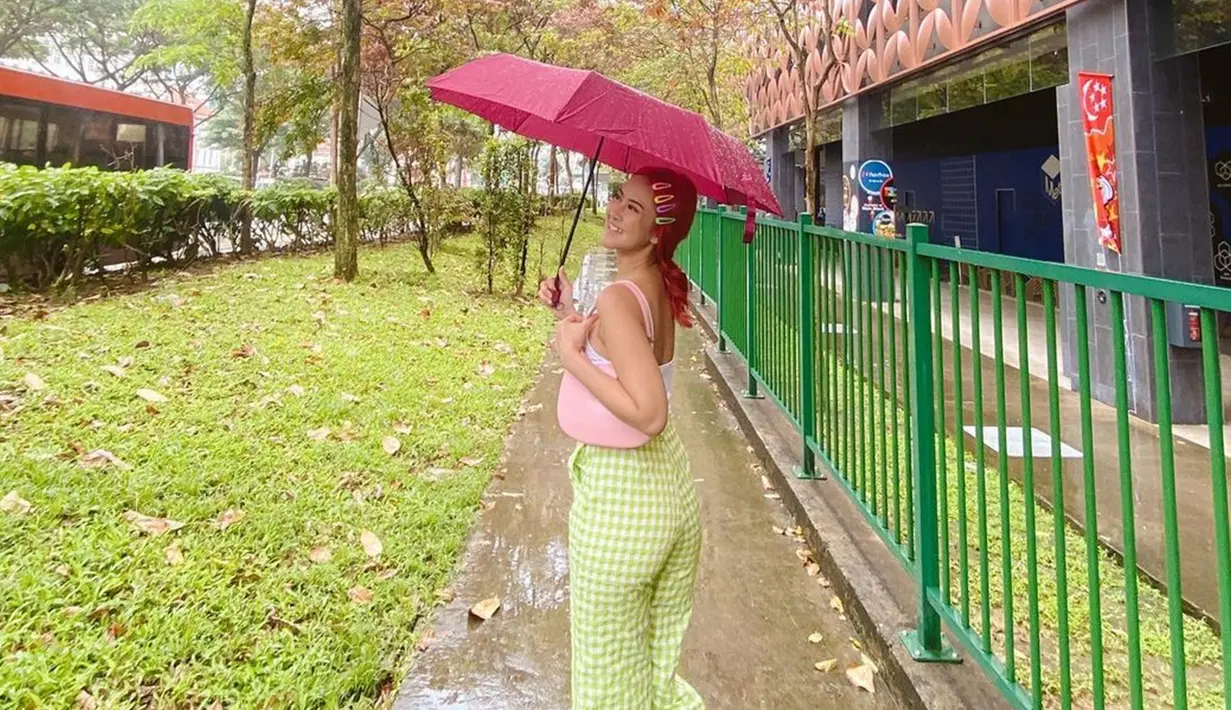 Memilih mewarnai rambut dengan warna merah, penampilan artis kelahiran Yogykarta ini terlihat seperti barbie. Tambahan jepitan membuat Gabriella Larasati semakin lucu dan imut. Warna tas dan payung senada dengan rambutnya membuat foto Gabriella Larasati ini tampak menarik. (Liputan6.com/IG/@gabriellalarasati)
