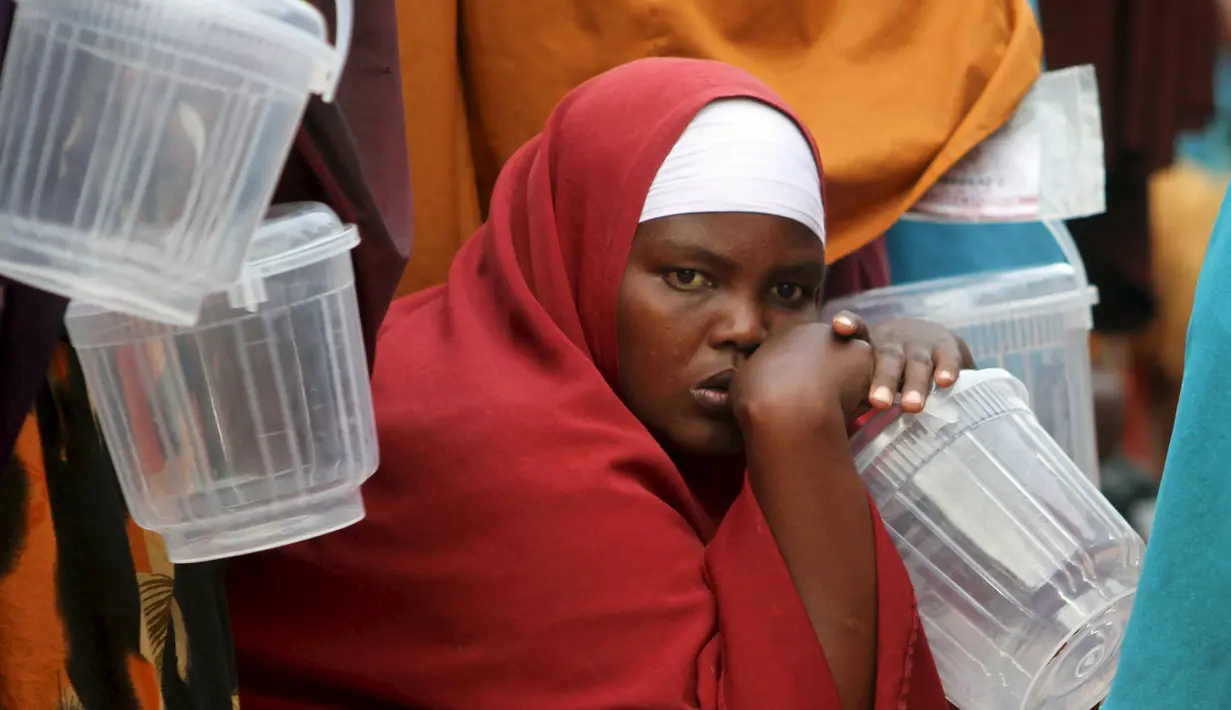 Seorang warga Somalia tampak mengantre untuk mendapatkan iftar (makanan berbuka puasa) dari sebuah organisasi amal Qatar selama bulan suci Ramadan, di ibukota Mogadishu, Senin (22/6/2015). (REUTERS/Feisal Omar)