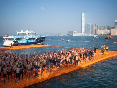 Perenang berpose di titik awal pada lomba renang tahunan melintasi Pelabuhan Victoria Hong Kong, Minggu (12/12/2021). Lomba renang tahunan itu diadakan untuk pertama kalinya dalam tiga tahun, setelah dibatalkan karena aksi demonstrasi besar-besaran dan kemudian pandemi COVID-19. (Bertha WANG/AFP)