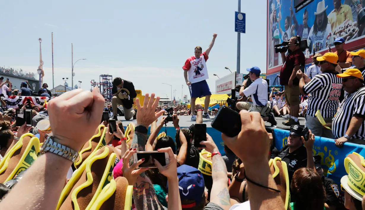 Joey Chestnut melakukan selebrasi usai memenangkan Kontes Makan Internasional Nathan, di New York, AS (4/7). Joey Chestnut menang dengan menghabiskan 72 hot dog dalam 10 menit. (AP Photo/Bebeto Matthews)