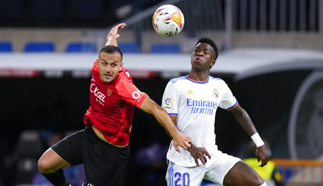Bek Mallorca Joan Sastre (kiri) dan penyerang Real Madrid Vinicius Junior berebut bola pada jornada keenam La Liga Spanyol di Santiago Bernabeu, Kamis (23/9/2021) dini hari WIB. Real Madrid berpesta gol usai melibas Real Mallorca 6-1. (AP Photo/Manu Fernandez)