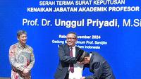 Rektor UII Yogyakarta, Fathul Wahid (tengah) saat penyerahan kenaikan jabatan akademik profesor Ilmu Ekonomi Kelembagaan kepada Unggul Priyadi. (Kukuh Setyono)