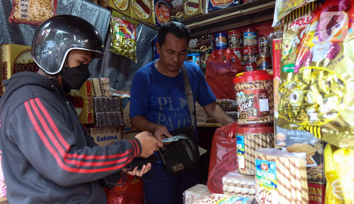 Pedagang kue kering melayani pembeli di salah satu toko di kawasan Ciracas, Jakarta, Kamis (19/4/2023). (Liputan6.com/Herman Zakharia)