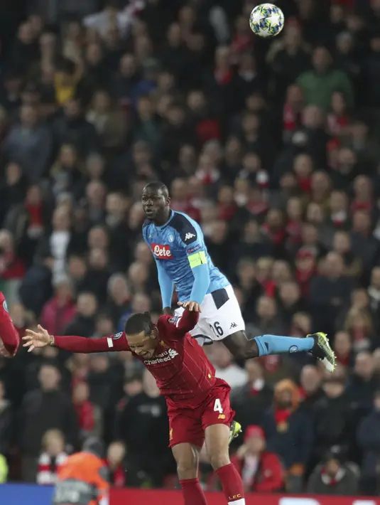 Bek Napoli, Kalidou Koulibaly berebut bola udara dengan bek Liverpool, Virgil van Dijk pada pertandingan Grup E Liga Champions di stadion Anfield, Inggris (27/11/2019). Liverpool bermain imbang 1-1 atas Napoli. (AP Photo/Jon Super)
