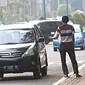 Joki 3 in 1 menawarkan jasa tumpangan kepada kendaraan roda empat di Senayan, Jakarta, Selasa (29/3). Gubernur DKI Jakarta Ahok berencana menghapus kebijakan 3 in 1 di jalan-jalan protokol. (Liputan6.com/Immanuel Antonius)