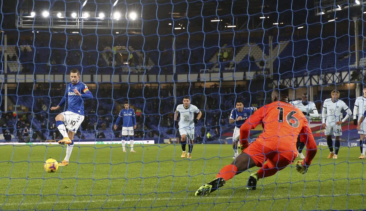 Gelandang Everton, Gylfi Sigurdsson saat memasukan bola lewat titik penalti ke gawang Chelsea pada pertandingan lanjutan Liga Inggris di Goodison Park di Liverpool, Inggris, Minggu (13/12/2020). Everton menang tipis atas Chelsea 1-0. (Clive Brunskill/Pool via AP)