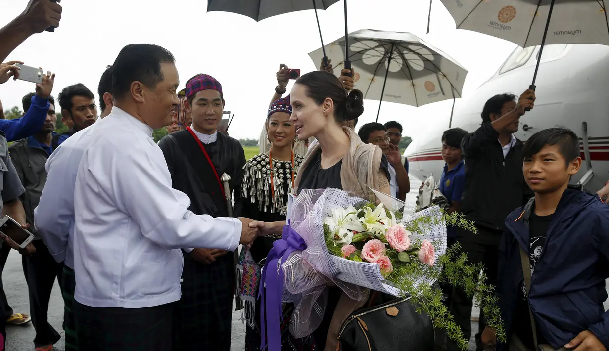 Utusan khusus UNHCR, Angelina Jolie berjabat tangan dengan Menteri Negara bagian Kachin, La John Ngan Hsai saat tiba di Bandara Myitkyinam, Myanmar, Rabu (30/7/2015). (REUTERS/Soe Zeya Tun)