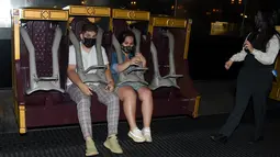 Para tamu menikmati wahana permainan pada hari pembukaan pemegang tiket musiman dan tahunan Universal Studios di Los Angeles, California, Kamis (15/4/2021). Universal Studios Hollywood akan dibuka kembali pada 16 April setelah lebih dari setahun tutup karena Pandemi covid-19. (LISA O'CONNOR/AFP)