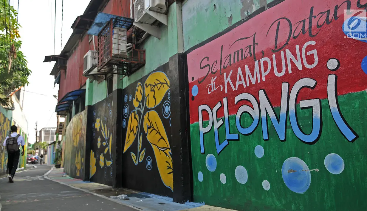 Anak sekolah berjalan di antara tembok warna-warni di Kampung Pelangi, Johar Baru, Jakarta, Rabu (2/5). Wilayah ini disebut Kampung Pelangi setelah warga dibantu petugas PPSU mempercantik gang dan tembok rumah dengan gambar. (Merdeka.com/Iqbal Nugroho)