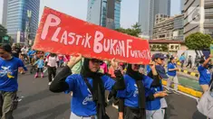 Sejumlah pegiat lingkungan membawa poster saat pawai bebas plastik di Kawasan Sudirman, Jakarta, Minggu (30/7/2023). (Liputan6.com/Faizal Fanani)