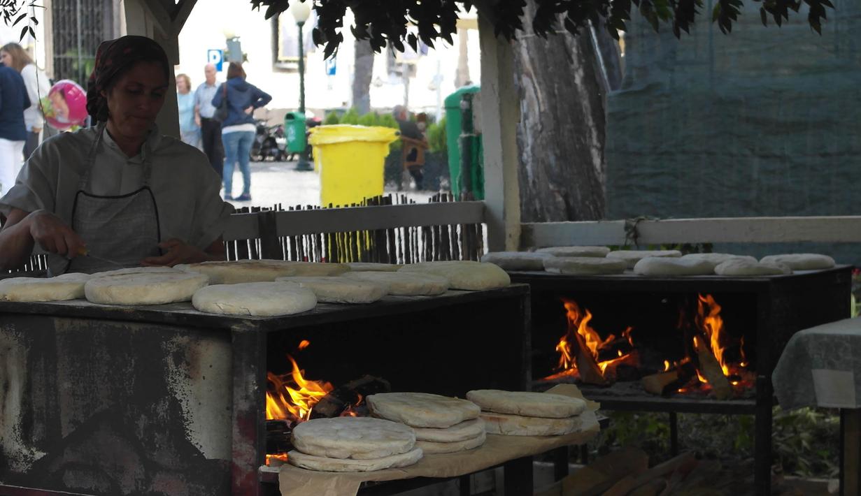 Seorang warga sedang membuat roti khas Madeira saat berada di Funchal, Portugal. Kota ini merupakan tempat bintang Real Madrid, Cristiano Ronaldo, lahir dan dibesarkan. (Bola.com/Reza Khomaini)