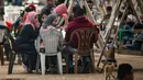 Warga Palestina berkumpul untuk berbagi makanan buka puasa selama bulan suci Ramadan, saat pandemi virus corona, di sepanjang pantai kota Gaza pada 13 Mei 2020. Mereka menunggu waktu berbuka puasa sambil menyaksikan matahari terbenam. (Photo by MAHMUD HAMS / AFP)