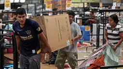 Warga membawa kulkas dari toko yang dijarah di Veracruz, Meksiko, (5/1). Akibat kejadian tersebut mengakibatkan kematian seorang polisi dan seorang saksi. (AP Photo / Felix Marquez)