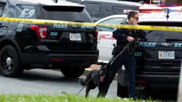 Polisi satwa atau K9 menelusuri lokasi kejadian setelah penembakan brutal di kantor surat kabar lokal di Annapolis, AS, Kamis (28/6). Polisi belum diketahui motif di balik aksi penembakan yang dilakukan di koran Capital Gazette itu. (AP/Jose Luis Magana)