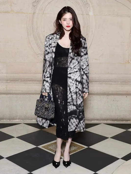 Penampilan Han So Hee jadi salah satu yang ditunggu-tunggu. Aktris 29 itu tampil berani memamerkan lekuk tubuhnya dalam balutan gaun renda tembus pandang yang dipadukan Dior Spring-Summer 2024 printed beige coat dan tas Dior. [Dok/Dior]