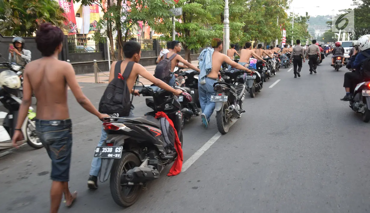Suasana saat ratusan pelajar SMA mendorong sepeda motor mereka di Bundaran Simpang Lima, Semarang, Jawa Tengah, Kamis (3/5). Konvoi para pelajar dilakukan usai pengumuman hasil UN tingkat SMA/SMK. (Liputan6.com/Gholib)