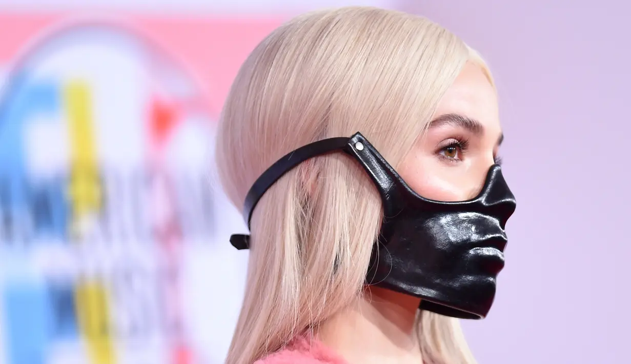 Penyanyi muda, Poppy menghadiri ajang penghargaan American Music Awards 2018 di Microsoft Theater, Los Angeles, Selasa (9/10). Namun, Poppy melengkapi penampilannya dengan masker hitam yang nyaris menutupi wajahnya. (Valerie MACON / AFP)