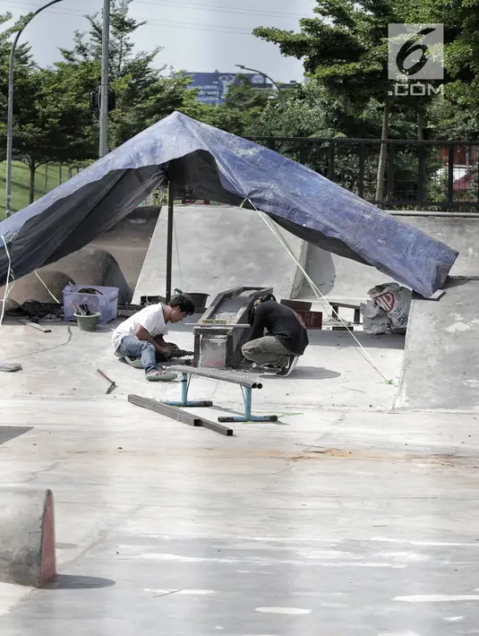 Pekerja memperbaiki arena skateboard yang rusak di RPTRA Kalijodo, Jakarta, Kamis (24/1). Perbaikan dilakukan untuk membuat rasa aman dan nyaman pengunjung yang menggunakan arena tersebut. (Liputan6.com/Faizal Fanani)