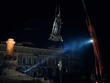 Para pekerja memindahkan monumen untuk Catherine II yang juga dikenal sebagai "Monumen Pendiri Odesa" di Odesa, Ukraina, 29 Desember 2022. Keputusan untuk membongkar monumen yang terdiri dari patung Permaisuri Rusia Catherine II dan rekannya dibuat baru-baru ini oleh penduduk Odesa melalui pemungutan suara elektronik. (AP Photo/LIBKOS)