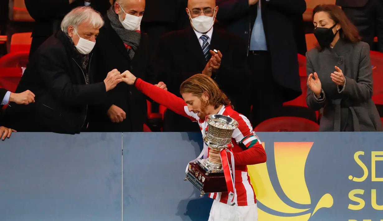 Penyerang Athletic Bilbao, Iker Muniain menerima trofi Piala Super Spanyol usai pertandingan final melawan Barcelona di stadion La Cartuja di Seville, Senin (18/1/2021). Bilbao sukses meraih juara Piala Super Spanyol usai mengalahkan Barcelona.3-2. (AFP/RFEF/Pablo Garcia)