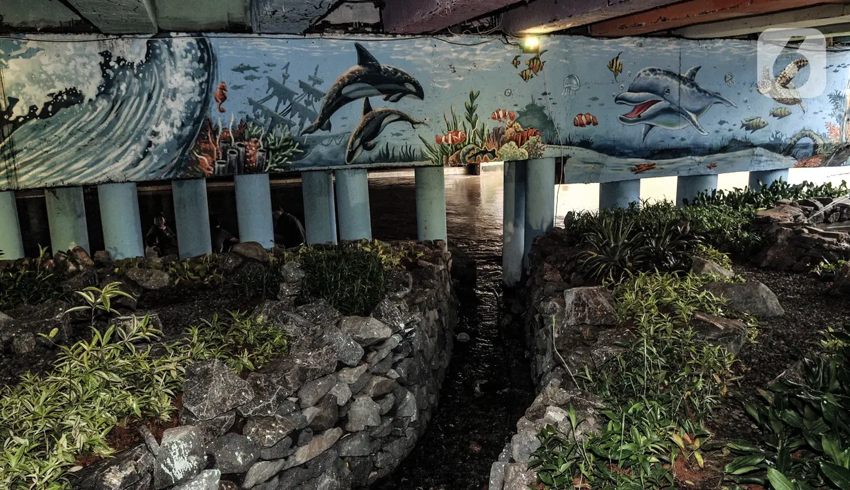 Mural bertema lingkungan hidup menghiasi taman kolong Jembatan Pegangsaan, Jakarta, Minggu (7/2/2021). Penataan taman di kolong Jembatan Pegangsaan kini telah dilengkapi tanaman hias, kolam ikan, mural, lampu warna-warni dan area untuk interaksi warga. (merdeka.com/Iqbal S Nugroho)