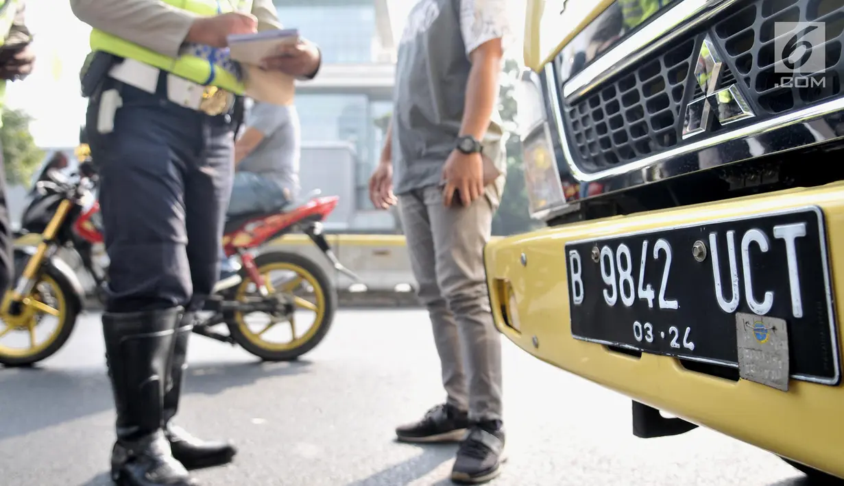 Polisi memeriksa kelengkapan surat-surat kendaraan saat hari pertama pemberlakuan perluasan sistem ganjil genap di Jalan Salemba Raya, Jakarta, Senin (9/9/2019). Pemprov DKI Jakarta memberlakukan perluasan sistem ganjil genap untuk mengurangi kemacetan dan polusi udara. (merdeka.com/Iqbal Nugroho)