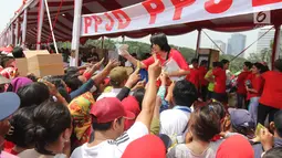 Panitia memberikan kaos kaki gratis dalam acara "Untukmu Indonesia" di lapangan Monas, Jakarta, Sabtu (28/4). Acara ini dimeriahkan oleh sejumlah kegiatan seperti pertunjukkan seni dan khitanan massal. (Liputan6.com/Arya Manggala)