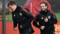 Senyum pemain Manchester United, Daley Blind (kanan) saat melakukan pemanasan bersama Victor Lindelof di club training complex, Carrington, Manchester, (11/9/2017). MU akan melawan FC Basel di grup A Liga Champions. (AFP/Paul Ellis)