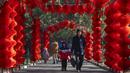 <p>Seorang pria dan anak laki-laki berjalan di sepanjang jalan yang dihiasi lentera untuk Tahun Baru Imlek mendatang di sebuah taman umum di Beijing, Jumat, 20 Januari 2023. Tahun Kelinci secara resmi dimulai pada 22 Januari. (AP Photo/Mark Schiefelbein)</p>