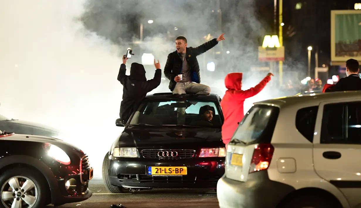 Warga Turki berkumpul menggelar protes di Rotterdam, Belanda (11/3). Aksi protes dilancarkan setelah Pemerintah Belanda melarang Menteri Luar Negeri Turki mendarat di Belanda. (AFP/Emmanuel Dunand)