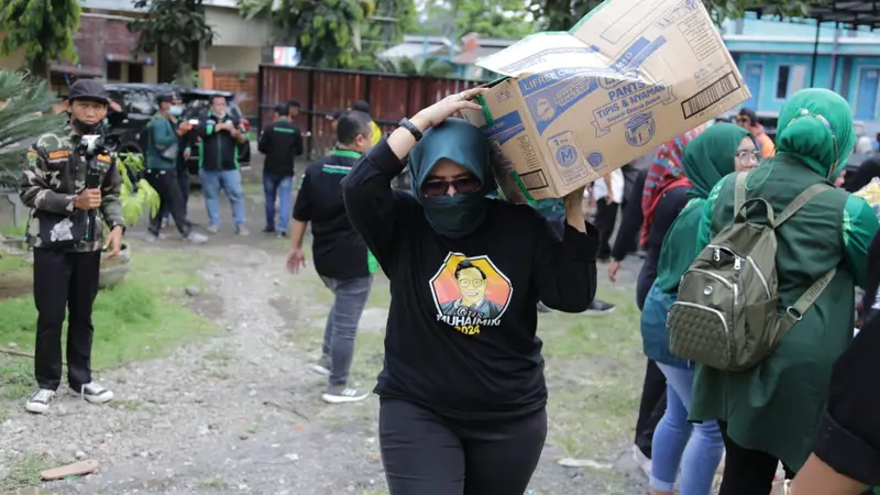 Wakil Ketua DPRD Jatim, Anik Maslachah menggotong   bantuan untuk korban erupsi Semeru di Posko Bencana. (Foto: Istimewa).