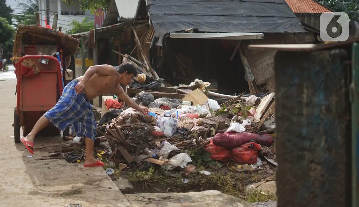 Warga membersihkan sampah setelah banjir merendam kawasan Cipinang Muara, Jakarta, Rabu (26/2/2020). Banjir dari luapan Sungai Kalimalang tersebut menyebabkan warga harus bekerja ekstra untuk membersihkan perabotan serta lumpur dan sampah. (Liputan6.com/Immanuel Antonius)