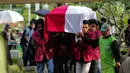 Sejumlah mahasiswa mengangkat peti jenazah Benny Soemarno saat akan dimakamkan di TPU Karet Bivak, Jakarta, Senin (2/4). Benny Soemarno meninggal pada usia 68 tahun. (Liputan6.com/Faizal Fanani)