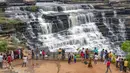 Orang-orang berfoto di depan Air Terjun Rajdari pada hari musim panas yang terik di distrik Chandauli, negara bagian Uttar Pradesh, India (28/6/2021).  Air Terjun Rajdari adalah tempat piknik yang populer bagi orang-orang di sekitar area tersebut pada musim panas. (AP Photo/Rajesh Kumar Singh)