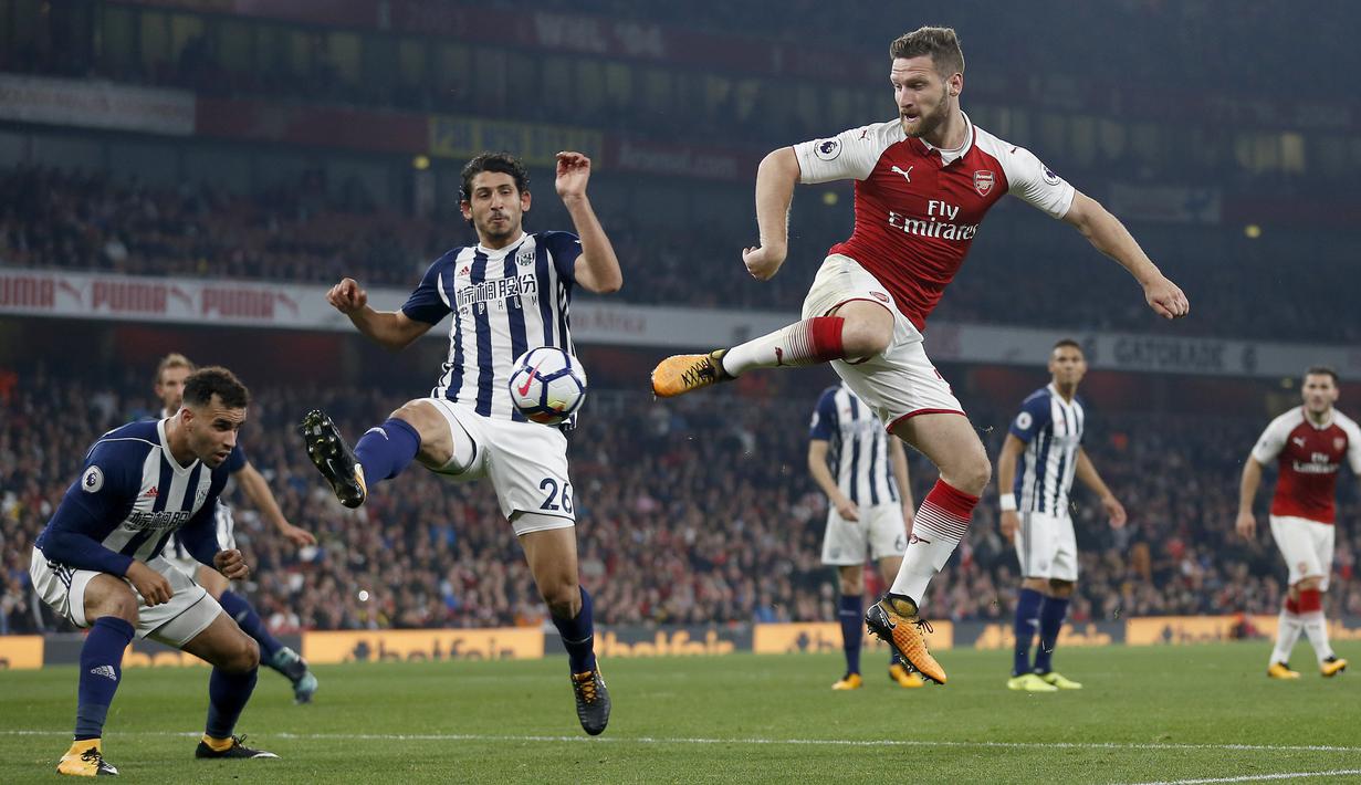 Pemain West Bromwich Albion, Ahmed Hegazy (kiri) mengadang sepakan pemain Arsenal,  Shkodran Mustafi pada lanjutan Premier League di Emirates stadium, London (25/9/2017). Arsenal menang 2-0. (AFP/Ian Kington)