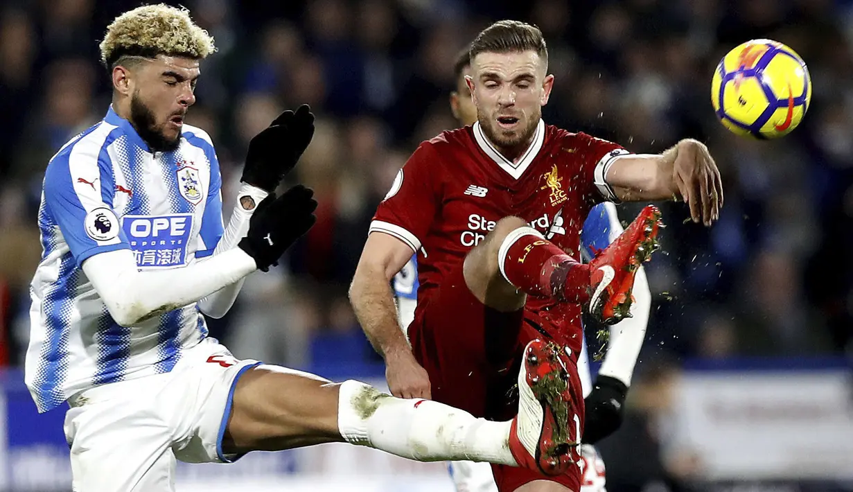 Aksi pemain Liverpool, Jordan Henderson (kanan) menghalau bola dari kaki pemain Huddersfield Town, Philip Billing pada lanjutan Premier League di John Smith's Stadium, Huddersfield, (30/1/2018). Liverpool menang 3-0. (Martin Rickett/PA via AP)