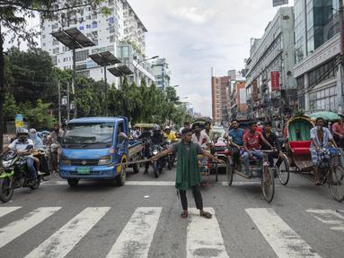Seorang relawan mengatur lalu lintas jalan raya di Dhaka, Bangladesh, Selasa (6/8/2024). (AP Photo/Rajib Dhar)