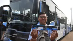 Warga memperlihatkan miniatur Bus transjakarta bermerek Scania saat acara peluncuran di Silang monas, Jakarta, Senin (22/6/2015). Ada sebanyak 20 unit bus transjakarta bermerek Scania yang diluncurkan pertengahan Juni ini. (Liputan6.com/Herman Zakharia)