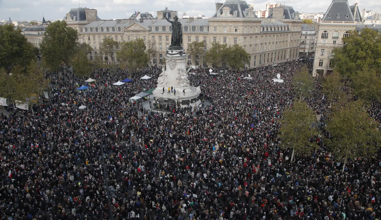 Ribuan orang berkumpul di alun-alun Republique selama demonstrasi di Paris (18/10/2020). Mereka berkumpul untuk memberi penghormatan kepada seorang guru sejarah, Samuel Paty yang dipenggal kepalanya di Paris setelah mendiskusikan karikatur Nabi Muhammad di kelasnya. (AP Photo/Michel Euler)