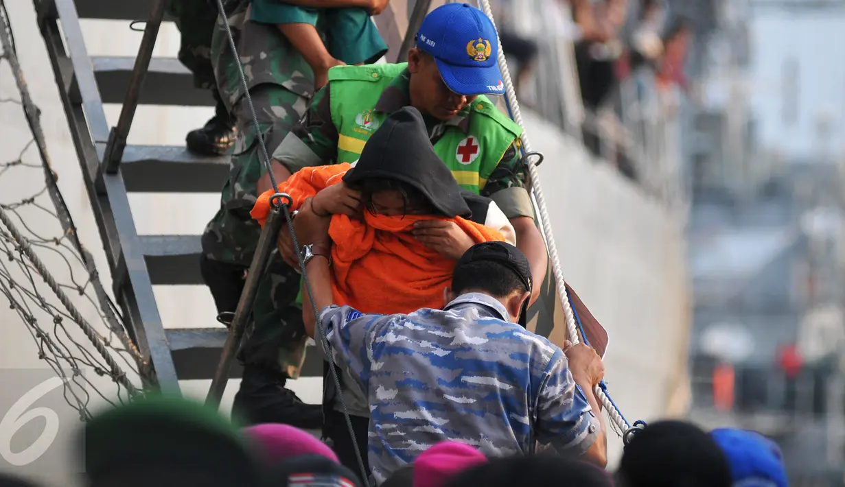 Petugas membantu warga eks Gafatar saat turun dari KRI Teluk Bone 551 di Pelabuhan Tanjung Priok, Jakarta, Kamis (28/1/2016). Sebanyak 824 warga eks Gafatar dipulangkan dari Kalimantan untuk dikembalikan ke daerah asal. (Liputan6.com/Gempur M Surya)