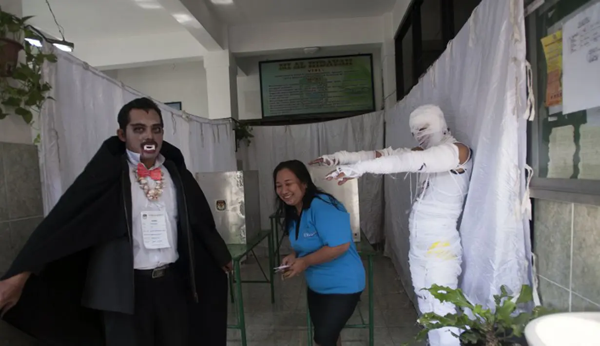 Para petugas di TPS ini kompak memakai kostum meyeramkan yang menyerupai drakula, Mummi dan jenis hantu lainnya, Surabaya, Rabu (9/7/2014) (AFP PHOTO/JUNI KRISWANTO)