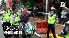Seorang pengendara motor menolak ditilang oleh polisi karena tidak memiliki surat izin mengemudi (SIM). Pengendara beralasan polisi tidak memiliki surat perintah dalam melakukan razia.