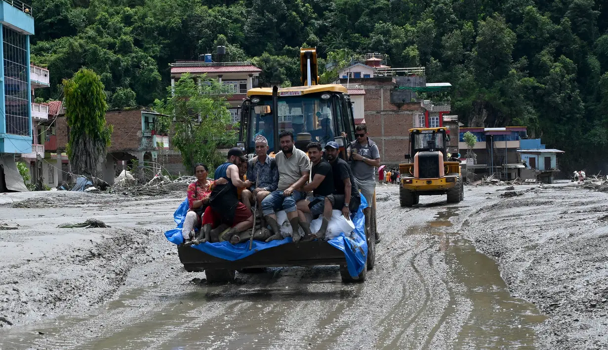 Petugas penyelamat mengangkut warga yang terjebak menggunakan buldoser setelah banjir bandang melanda kawasan Devighat di distrik Nuwakot, Nepal, Kamis, pada 27 Agustus 2026. (AFP/ Prakash Mathema)