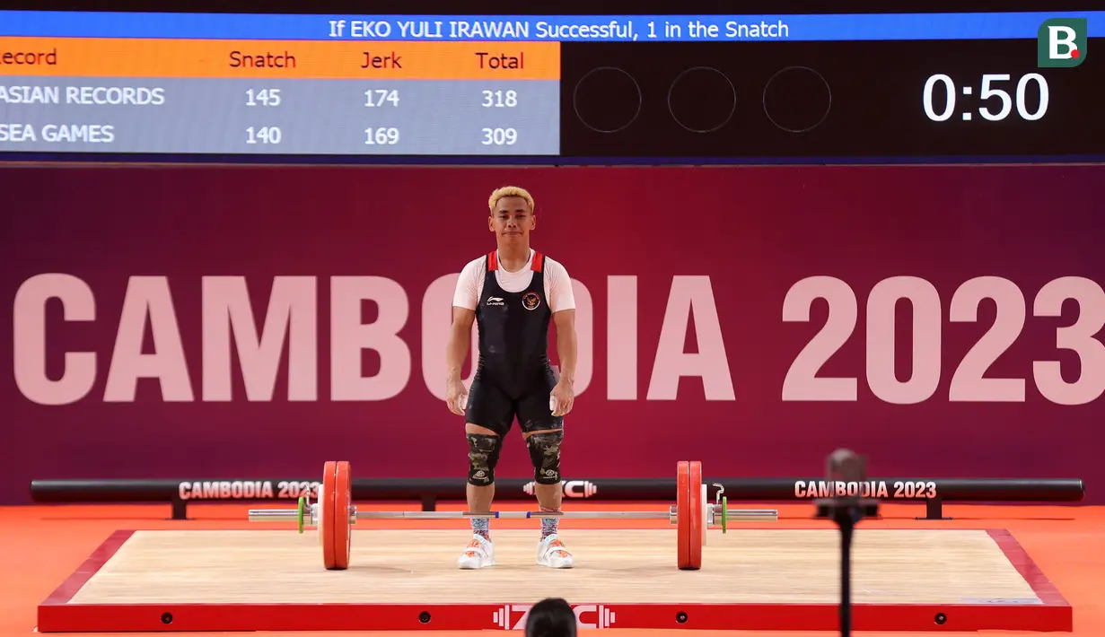 <p>Atlet angkat besi Indonesia, Eko Yuli Irawan berkompetisi pada nomor angkat besi putra 61 kg SEA Games 2023 di Taekwondo Hall Olympic Complex, Phnom Penh, Kamboja, Sabtu (13/05/2023). (Bola.com/Abdul Aziz)</p>