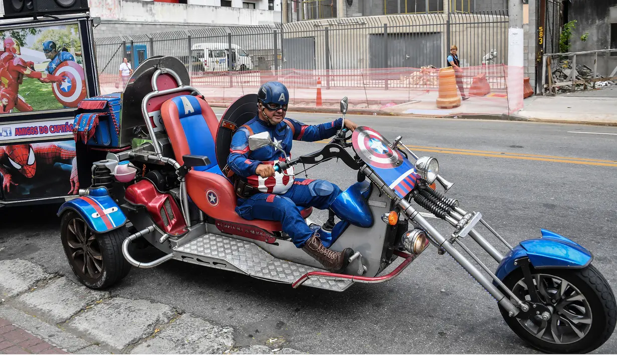 Wakil kandidat untuk Partai Sosial Liberal (PSL), Luiz Carlos de Paula yang dikenal sebagai Captain America menunggangi motor besar beroda tiga saat melakukan kampanye di Sao Paulo, Brasil, 26 September 2018. (AFP/NELSON ALMEIDA)