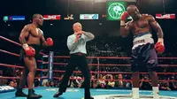 Mike Tyson dan Evander Holyfield kembali berduel di MGM Grand Garden Arena, Las Vegas pada 28 Juni 1997. Akan tetapi, laga akbar ini harus dihentikan pada ronde ketiga, karena Tyson menggigit kuping Holyfield. (AFP/JEFF HAYNES)