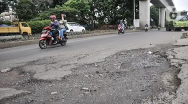 Pengendara sepeda motor melintasi Jalan Raya Bekasi,  yang rusak dan berlubang di Cakung, Jakarta Timur, Selasa (14/3/2023). Minimnya perawatan menyebabkan kondisi Jalan Raya Bekasi arah Cakung ke Pulogebang rusak dan berlubang yang dapat membahayakan keselamatan pengendara, terlebih saat musim penghujan. (merdeka.com/Iqbal S Nugroho)