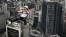 Penerjun Swiss Samuel Schumacher melompat dari dek terbuka Menara Kuala Lumpur saat International Tower Jump, Kuala Lumpur, Malaysia, 3 Februari 2023. Lebih dari 100 penerjun melompat dari Menara Kuala Lumpur setinggi 300 meter yang terkenal tersebut. (MOHD RASFAN/AFP)