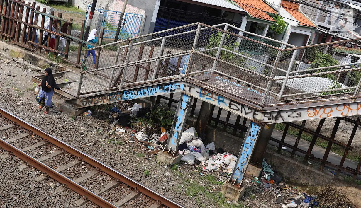 Warga melintas di bawah JPO berkarat dan tidak terawat di kawasan Tebet, Jakarta, Selasa (6/3). Kondisi JPO yang memprihatinkan menyebabkan sebagian warga memilih untuk tidak menggunakannya karena membahayakan keselamatan. (Liputan6.com/Immanuel Antonius)